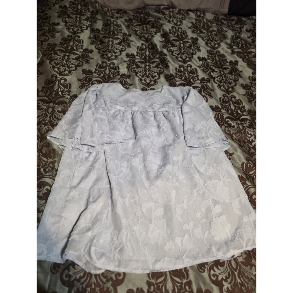 XL light blue top features delicate,‎ textured floral details & ruffled
